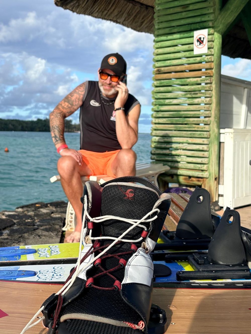 Gordon Brown taking a call by the sea on holiday, with water skis in the foreground
